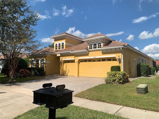 mediterranean / spanish-style home featuring stucco siding, decorative driveway, an attached garage, and a tile roof