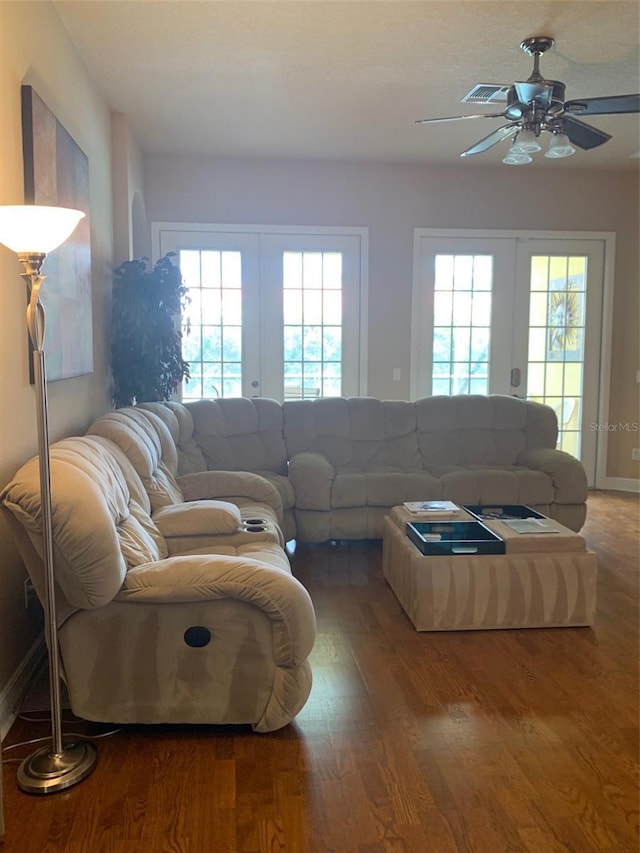 living area featuring french doors, a ceiling fan, and wood finished floors