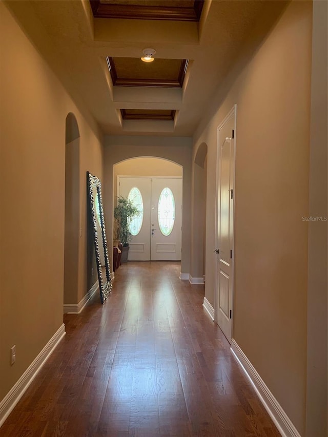 interior space with arched walkways, dark wood-style flooring, baseboards, and ornamental molding
