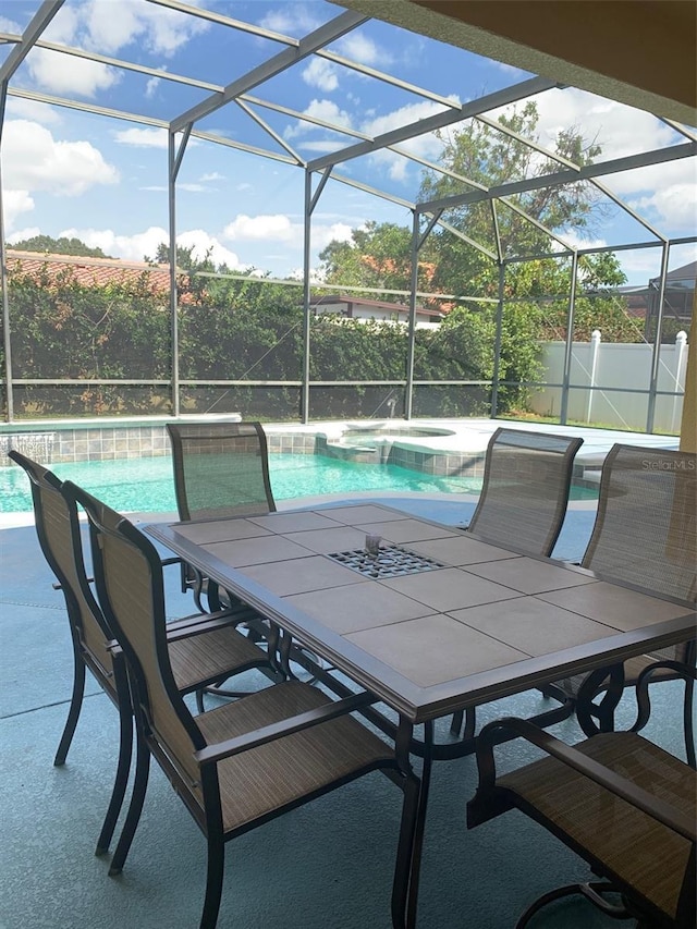 view of patio featuring a lanai, outdoor dining area, a fenced in pool, and a hot tub