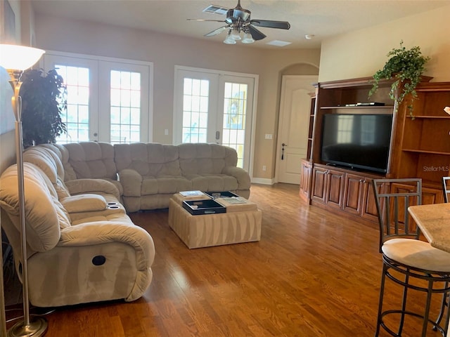 living room featuring french doors, wood finished floors, plenty of natural light, and ceiling fan