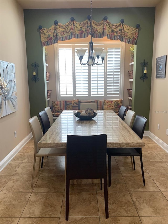 dining room featuring baseboards, a chandelier, and light tile patterned flooring
