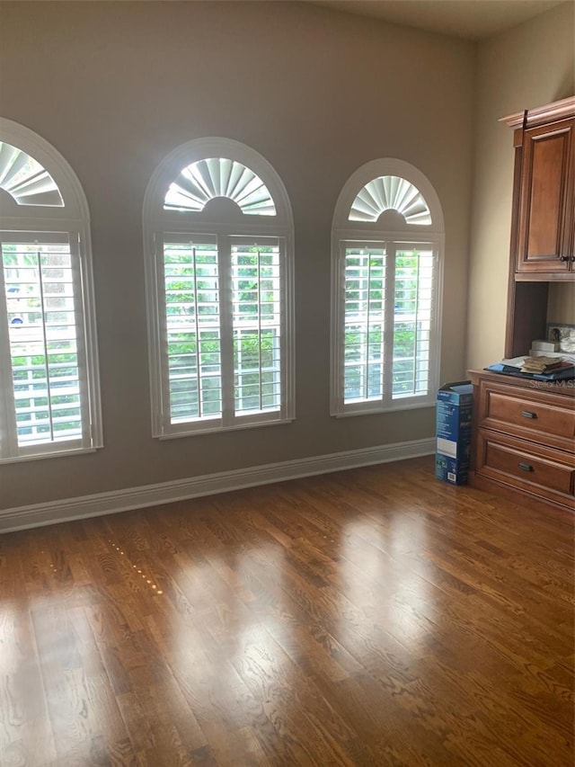 spare room with wood finished floors and baseboards