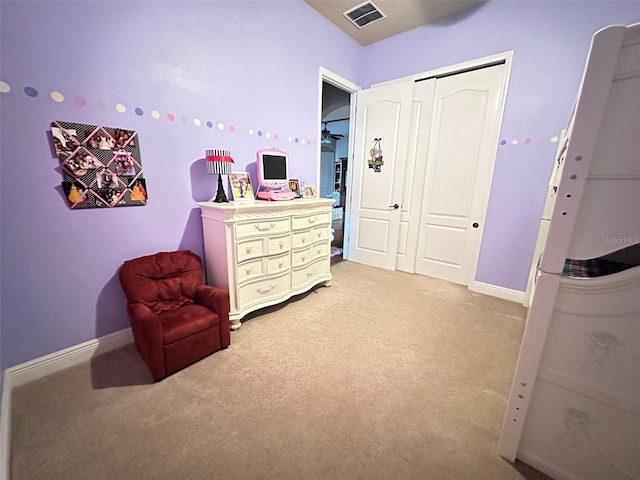 bedroom with light carpet, visible vents, a closet, and baseboards