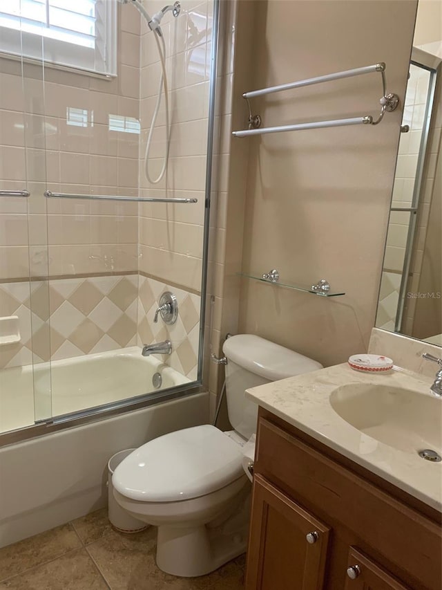 bathroom with tile patterned flooring, combined bath / shower with glass door, toilet, and vanity
