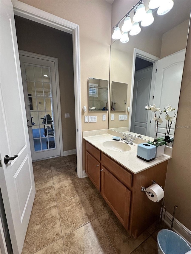 bathroom featuring tile patterned floors, baseboards, and vanity