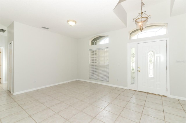 tiled entrance foyer with an inviting chandelier and a wealth of natural light