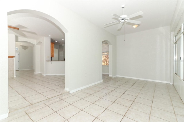 tiled spare room featuring ceiling fan