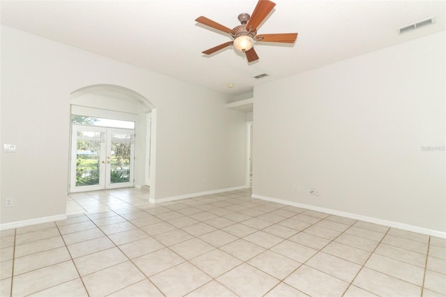 spare room featuring light tile patterned floors, ceiling fan, and french doors