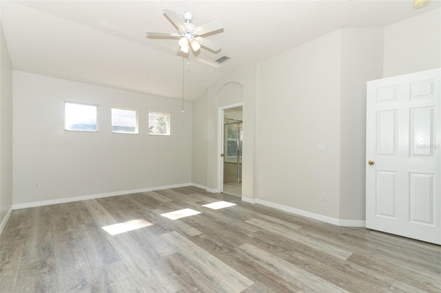 spare room with ceiling fan, lofted ceiling, and light wood-type flooring