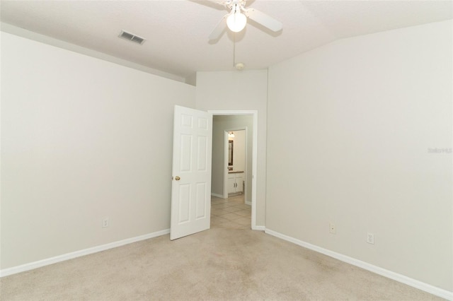 carpeted spare room featuring ceiling fan and vaulted ceiling