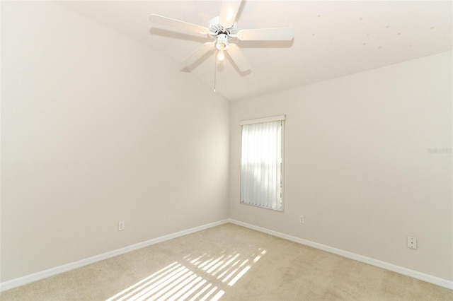 carpeted spare room featuring ceiling fan and vaulted ceiling