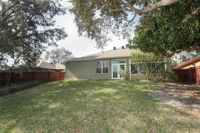 rear view of house featuring a lawn