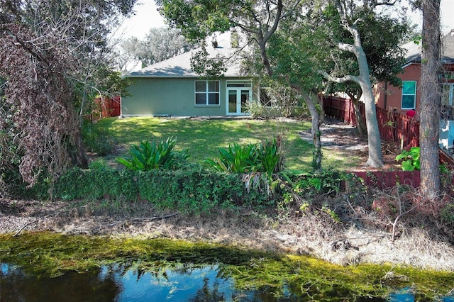 rear view of house with french doors and a lawn