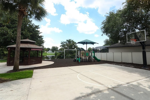 view of sport court featuring a gazebo, a water view, and a playground