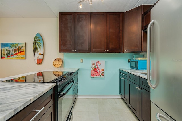 kitchen with light stone counters, dark brown cabinets, and black appliances