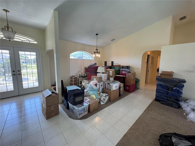 living room featuring plenty of natural light, vaulted ceiling, and light tile patterned flooring