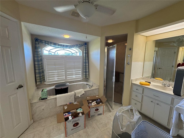 bathroom featuring ceiling fan, vanity, plus walk in shower, and tile patterned flooring