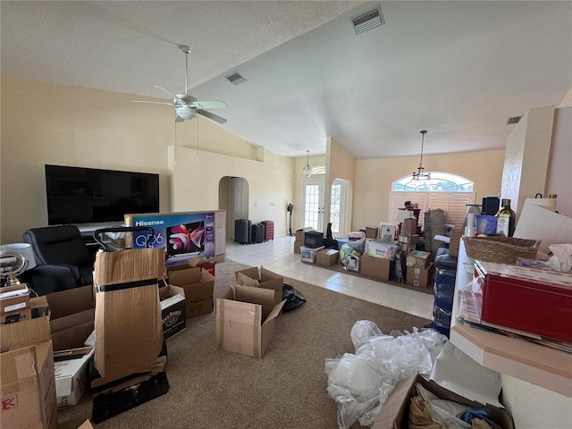 tiled living room with ceiling fan, lofted ceiling, and a textured ceiling