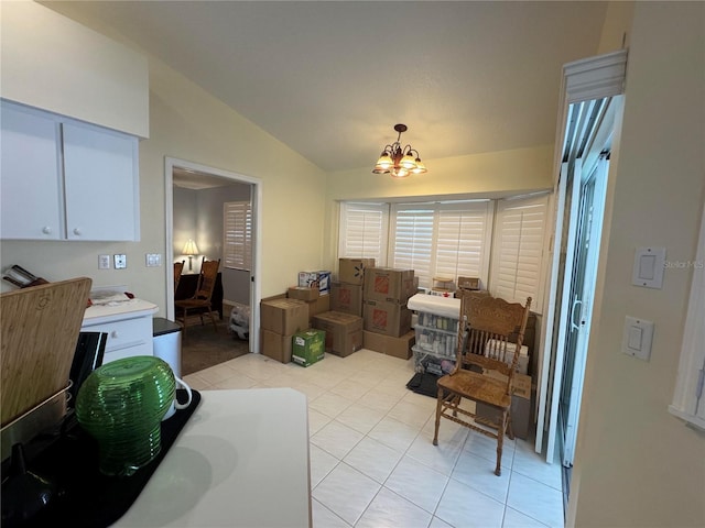 dining room featuring light tile patterned floors, vaulted ceiling, and a chandelier