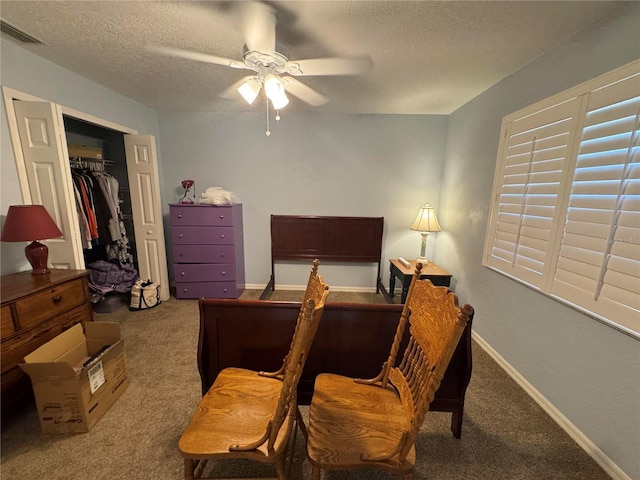 bedroom with ceiling fan, light colored carpet, a textured ceiling, and a closet