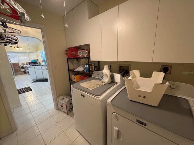 laundry area featuring cabinets, independent washer and dryer, and light tile patterned flooring