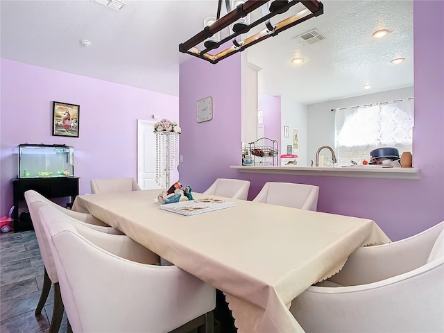 dining area with visible vents and a textured ceiling