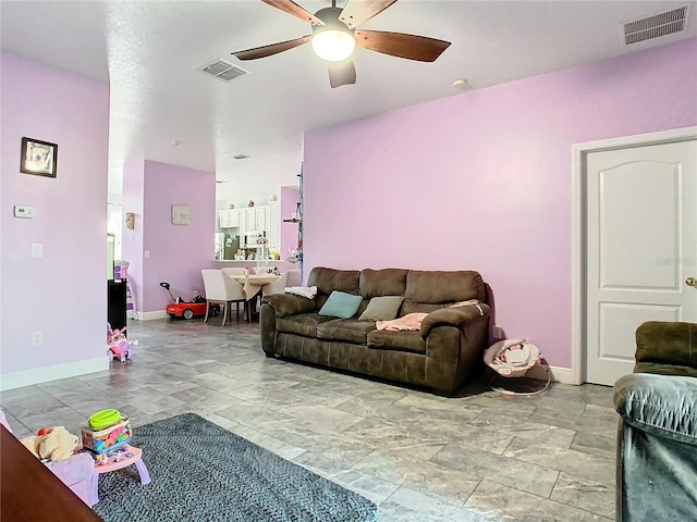 living room with baseboards, visible vents, and a ceiling fan