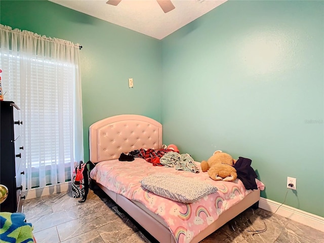 bedroom with a ceiling fan and baseboards