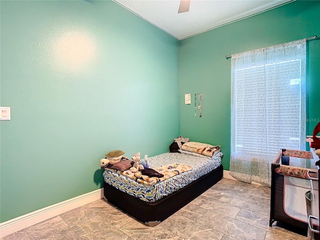 bedroom with a ceiling fan and baseboards