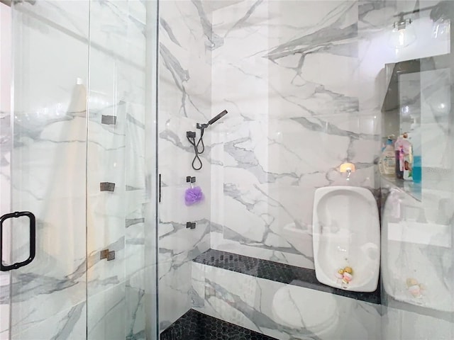 bathroom featuring a marble finish shower