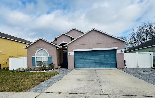 single story home with stucco siding, concrete driveway, fence, a garage, and a front lawn