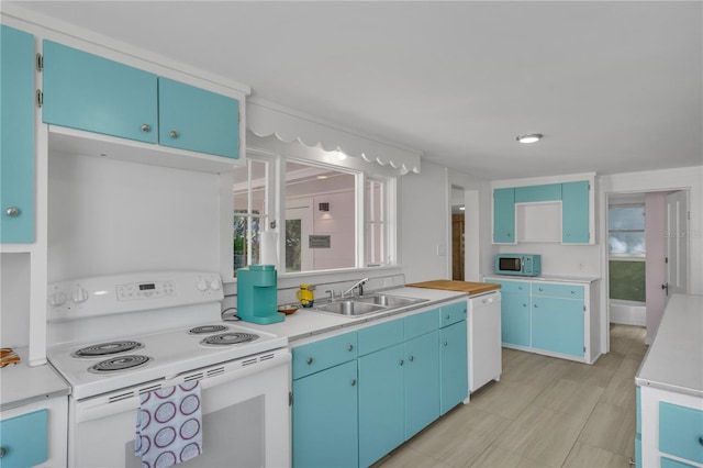 kitchen featuring white appliances, blue cabinets, and sink