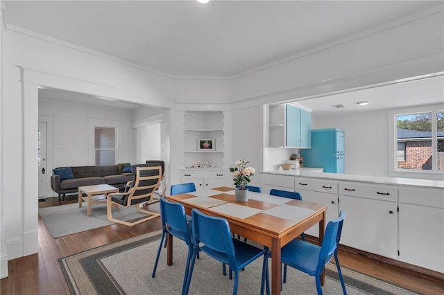 dining room with crown molding and dark hardwood / wood-style floors