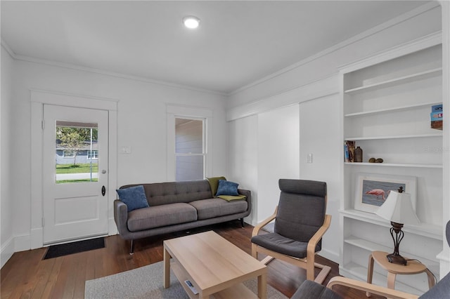 living room featuring dark hardwood / wood-style flooring, crown molding, and built in shelves