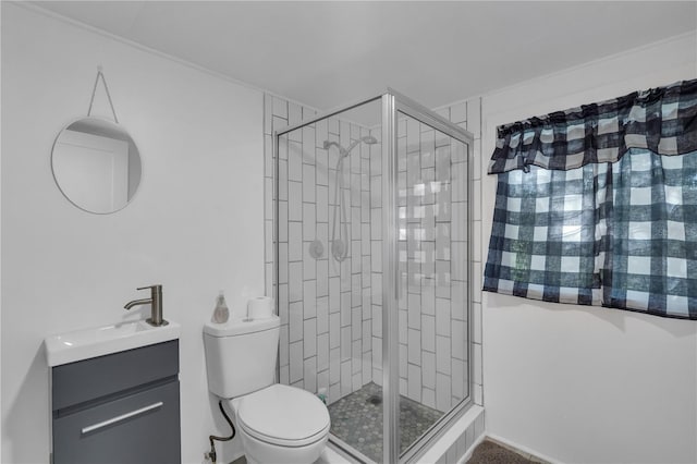 bathroom with vanity, tiled shower, and toilet