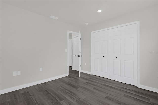 unfurnished bedroom featuring dark wood-type flooring and a closet