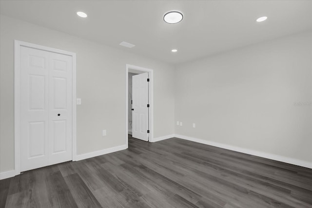 empty room with dark hardwood / wood-style flooring