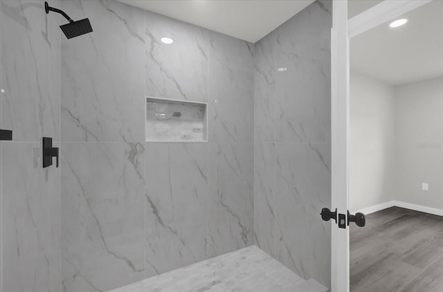 bathroom featuring tiled shower and hardwood / wood-style floors