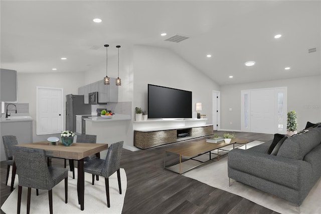 living room featuring lofted ceiling, sink, and light wood-type flooring