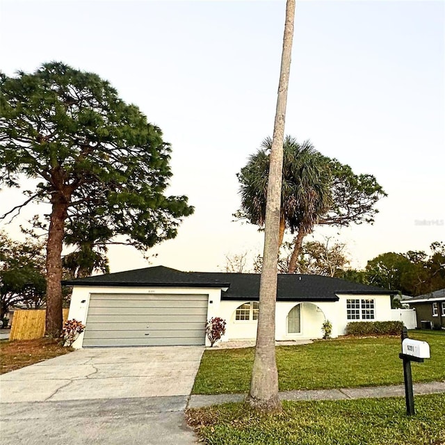 single story home featuring a garage and a front yard