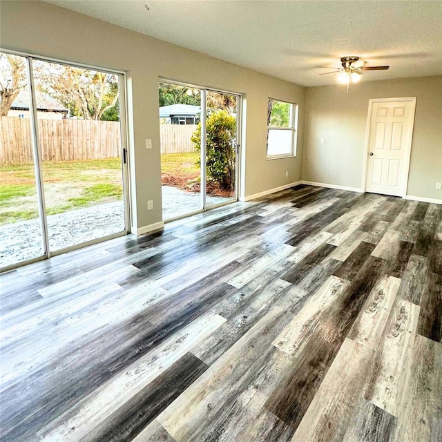 unfurnished room with hardwood / wood-style flooring, ceiling fan, and a textured ceiling