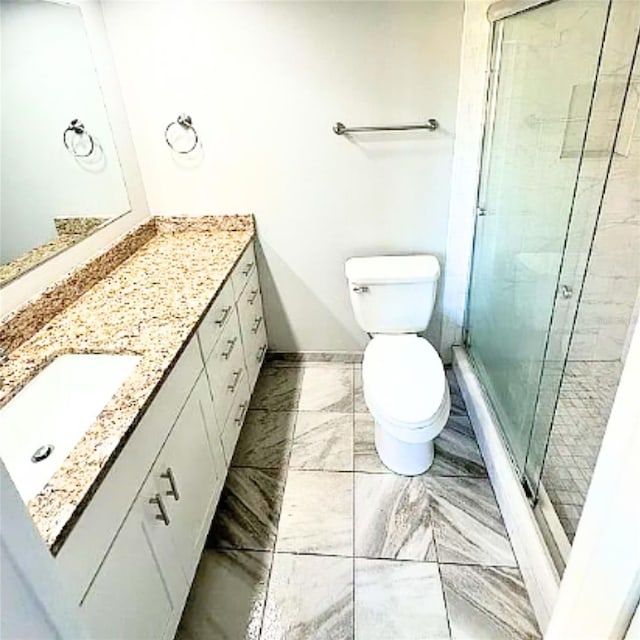 bathroom featuring vanity, toilet, and an enclosed shower