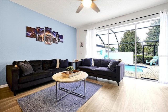 living room featuring ceiling fan, plenty of natural light, wood-type flooring, and a textured ceiling