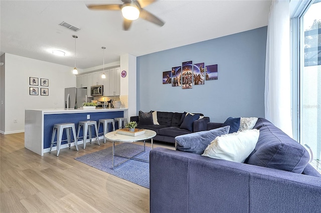 living room with ceiling fan and light hardwood / wood-style floors