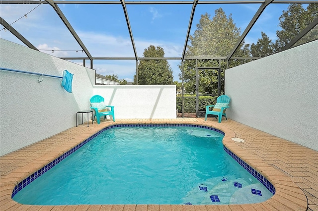 view of swimming pool with a patio area and glass enclosure