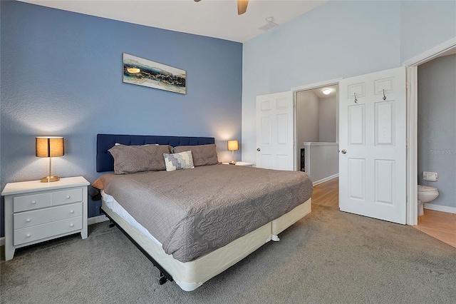 bedroom with carpet floors, ceiling fan, and ensuite bathroom