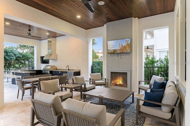 view of patio / terrace with an outdoor living space with a fireplace, area for grilling, sink, an outdoor kitchen, and ceiling fan