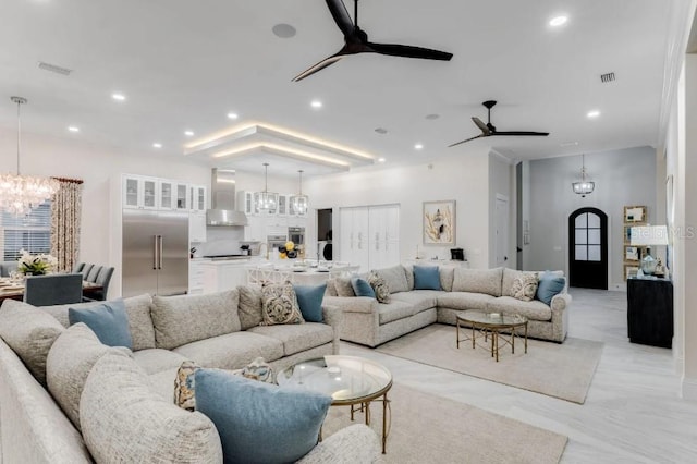 living room with ceiling fan with notable chandelier