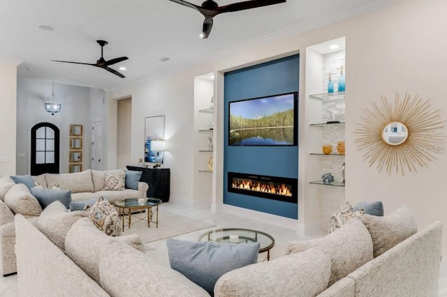 living room featuring ornamental molding, ceiling fan, and built in shelves